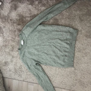 Ljusgrå stickad tröja från VILA - Mysig ljusgrå stickad tröja från VILA i storlek S. Tröjan har rund hals, ribbade muddar vid ärmslut och nederkant samt långärmad passform. Perfekt för dig som gillar enkel och clean stil.