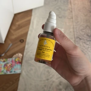 Sephora Ginger Face Serum 30 ml - Sephora Ginger Face Serum med pumpflaska, 30 ml. Serumet har en fräsch gul etikett och genomskinlig flaska med vitt lock. Innehåller ingefäraextrakt och är perfekt för att ge huden glow och jämnare ton. Flaskan är tillverkad av återvunnen plast. Doftar gott
