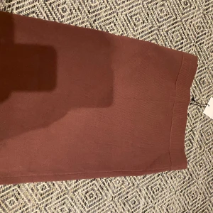 Brun stickad minikjol från NA-KD - Säljer en brun, stickad minikjol från NA-KD med hög midja. Kjolen har en enkel och stilren design utan mönster, perfekt för dig som gillar en clean look. Materialet är mjukt och stretchigt för en bekväm passform.