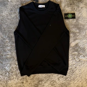 Stone Island Tjocktröja - Stilren svart långärmad tröja från Stone Island – en tidlös klassiker med ikonisk logga på ärmen. Perfekt balans mellan premiumkvalitet och avslappnad streetwear-look.  ♦️ Storlek S – normal passform ⚜️ Helt ny – med tag kvar ♦️ Ikonisk Stone Island-kompass på ärmen  📦 Fraktas inom 24 timmar & trygg affär
