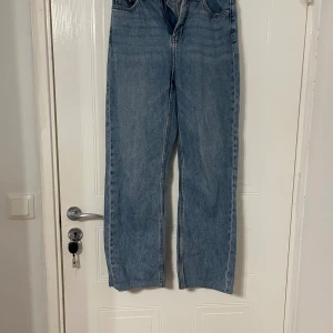 Blå raka jeans i denim, strl 38 - Säljer ett par klassiska blå jeans från Denim 1953 (KappAhl) i storlek 38. Jeansen har rak passform och normal midja, tillverkade i slitstark denim. Perfekta för en avslappnad och tidlös look.