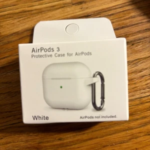 AirPods 3 Protective Case - Skydda dina AirPods 3 med detta vita skyddsfodral. Levereras i originalförpackning och inkluderar karbinhake för enkel fastsättning. Perfekt passform och extra skydd mot repor och stötar. 