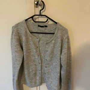 Grå kofta från 157 med knappar - Mysig grå kofta från 157 i storlek S. Koftan är stickad med rund halsringning och knäppning framtill med matchande knappar. OBS köp helst inte via Bring!