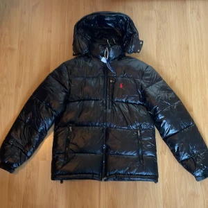 Ralph Lauren Jacka - Säljer denna riktigt feta jackan ifrån Ralph Lauren med glansig svart färg i storlek M. Mycket bra skick utan några defekter! Nypris ligger på över 6000 kr, mitt pris enbart 2499. Ej 100% säker på om den är äkta men tror det. Hör gärna av dig vid funderingar!