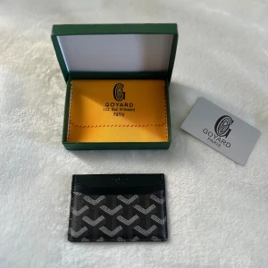 Svart kortfodral  - Snyggt svart kortfodral med ikoniskt grafiskt mönster i vitt och grått. Tillverkat i exklusivt skinn och levereras med originalask och certifikat. Perfekt för dig som vill ha en stilren och lyxig accessoar i fickan.