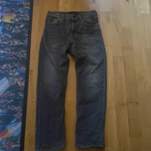 Mörkgrå jeans från Replay - Säljer ett par mörkgrå raka jeans från Replay. Klassisk femficksmodell med normal passform och snygg tvätt. Jeansen har en enkel design och är tillverkade i slitstarkt denimtyg. Perfekta för dig som gillar stilrena och tidlösa jeans.