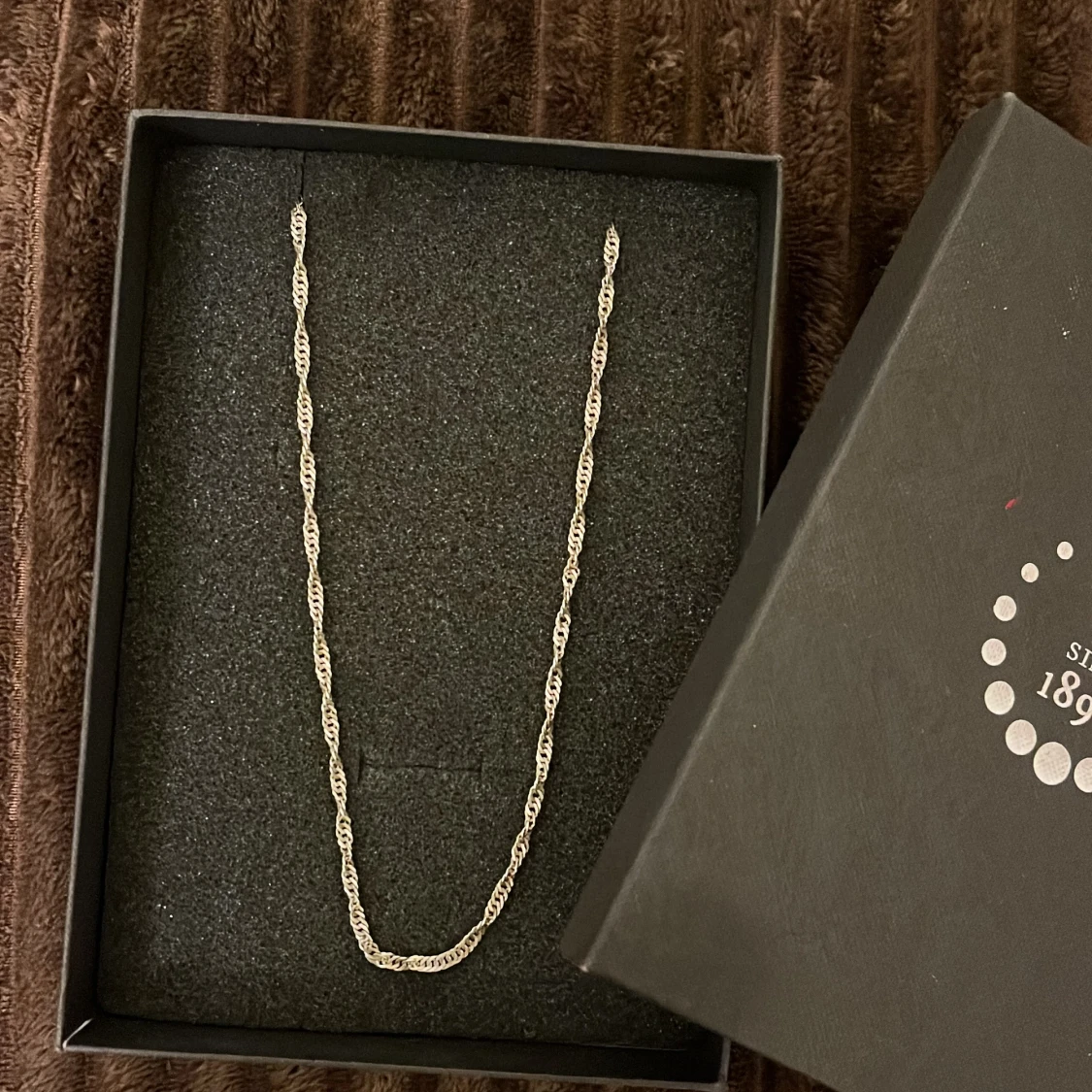 Tvinnad silverhalskedja i ask