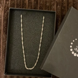 Tvinnad silverhalskedja i ask - Snygg halskedja i äkta silver med tvinnad design, levereras i original ask från Silversmed 1893. Kedjan har en klassisk rund låsning och passar perfekt för dig som gillar stilrena detaljer. Perfekt att bära som den är eller med ett hängsmycke.