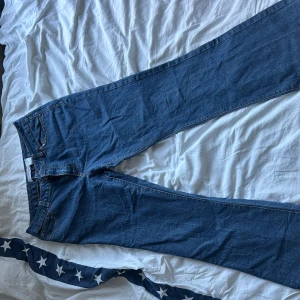 Blå jeans från Cherokee, storlek 14 - Snygga blå bootcutjeans från Cherokee i klassisk femficksmodell och låg midja. Jeansen är tillverkade i slitstarkt denimtyg med kontrastsömmar. Perfekta för dig som gillar en enkel och tidlös look.
