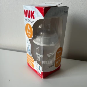 Nappflaska - Nappflaska från NUK First Choice+ för spädbarn 0-6 månader, med anti-kolik system och temperaturkontroll. Flaskan är BPA-fri och har söta djurmotiv.