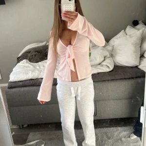 Ljusrosa knytblus från Gina Tricot - Supersöt ljusrosa blus från Gina Tricot i storlek XXS. Modellen har lång ärm, v-ringning och en snygg knytning framtill. Tunt och mjukt material som känns skönt mot huden💗Pris kan diskuteras