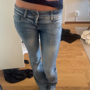 Ljusblå bootcut jeans med låg midja - Snygga blåa jeans med bootcut och låg midja. De har dubbelknappar och är supersköna🥰 Säljer pga att de inte används så mycket längre!