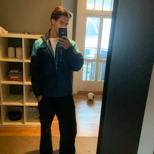 Regnjacka/Vindjacka från Oscar Jacobsson - En fin regnjacka/vindjacka från Oscar Jacobsson som är sparsamt använd och passar bra till hösten och skola/jobb. 