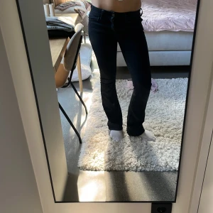 Svarta bootcut jeans från Gina Tricot - Säljer ett par svarta jeans från Gina Tricot i storlek 164. Modellen har bootcut-ben och klassisk femficksdesign med snygga detaljer vid fickorna. Jeansen är i ett stretchigt bomullsmaterial och har en mörk tvätt som passar till allt. Det saknas tyvärr en knapp på ena fickan. Skriv om du vill ha fler bilder😊