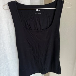 Svart linnetopp från 157 - Enkel svart linnetopp från 157 med rundad urringning och ärmlös design. 