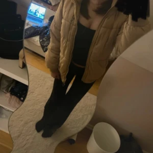 Beige pufferjacka från 157 - Säljer en beige pufferjacka från 157 med snygg quiltad design och dragkedja med rund metallring. Jackan har lång ärm och är fodrad med mjuk fleece på insidan, perfekt för kyliga dagar. Den är lite sönder som ni ser på andra bilden annars helt okej