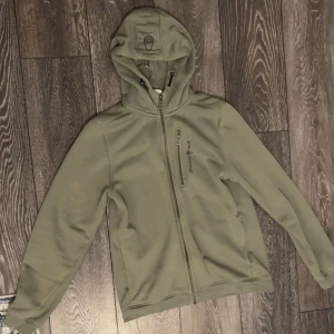 Grön hoodie från Sail Racing storlek XS/S - Snygg grön hoodie från Sail Racing. Storlek 176 men passar S. Liten svart plupp på baksidan men inget som märks går säkert bort i tvätten.