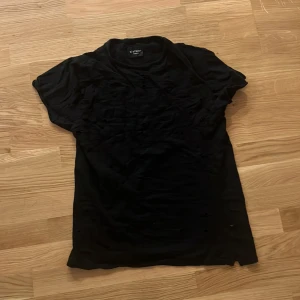 Svart t-shirt från D-Struct - Svart t-shirt från D-Struct med klassisk rund hals och korta ärmar. T-shirten har en enkel och stilren design, perfekt för en avslappnad look. Materialet känns mjukt och bekvämt mot huden.