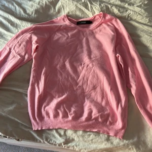 Rosa stickad tröja från Vero Moda - Superfin rosa stickad tröja från Vero Moda i storlek M. Tröjan har rund halsringning och långa ärmar, perfekt för lager på lager. Mjuk och skön känsla, enkel att matcha med jeans eller kjol.