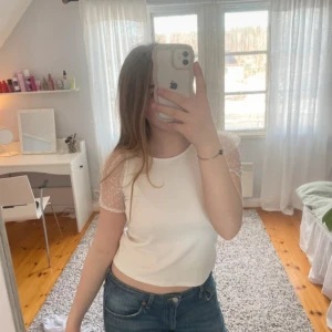 Vit topp med meshärmar - Supersöt vit topp från Lindex med korta puffiga meshärmar som har små prickar. Använd ett fåtal gånger med säljer då den börjar bli lite för liten.  Storlek 146/152 med skulle uppskatta som xs. 70% viskos, 25% polyester, 5% elastan.💕💕