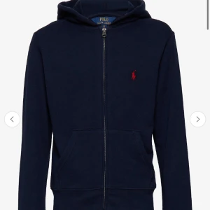 Marinblå hoodie från Polo Ralph Lauren - Snygg marinblå hoodie från Polo Ralph Lauren med dragkedja framtill och klassisk röd logga på bröstet. Det är unisex! Storlek XL i barnstorlek så typ XS