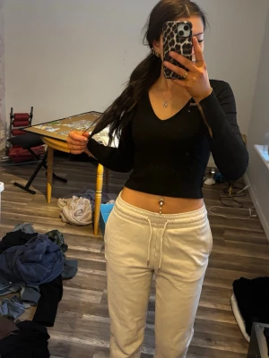 Beiga mjukisbyxor med snörning - Säljer ett par beiga mjukisbyxor med snörning i midjan och bekväma sidofickor. Byxorna har en loose passform och är gjorda i mjukt bomullsmaterial. Färgen är ljus beige och midjan är elastisk för extra komfort.