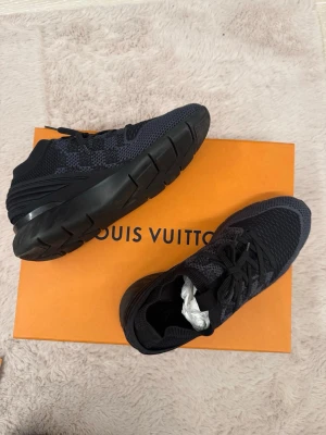 Louis Vuitton sneakers – Svarta – Lyx & komfort -    KVITTO FINNS !!! Säljer ett par exklusiva Louis Vuitton sneakers i svart – en perfekt kombination av lyx, streetstyle och komfort. Skorna har en modern, sportig design med diskret LV-mönster och en kraftig sula som ger både stil och stabilitet.  ✨ Detaljer: 	•	Färg: Svart 	•	Material: Textil/mesh med gummisula 	•	Design: Modern sneaker med lyxig finish 	•	Skick: Mycket fint / sparsamt använda (se bilder)•	Originalkartong medföljer✅KVITTO FINNS!!‼️