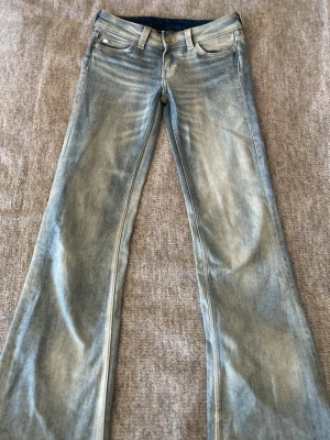 Bootcut jeans från Cheap Monday, 25/32  - Säljer ett par ljusblå bootcut jeans från Cheap Monday, modell Booty Bell. Klassisk femficksdesign, snyggt slitna detaljer och stor patch med logga bak. Materialet är 67% bomull, 32% polyester och 1% elastan för skön stretch. ALDRIG ANVÄNDA! 