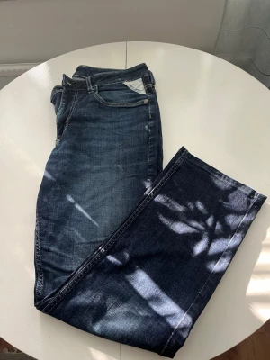 Mörkblå jeans i ekologisk bomull - Säljer ett par mörkblå jeans med klassisk femficksdesign och kontrastsömmar. Byxorna är tillverkade i ekologisk bomull och har en rak passform. Perfekta för dig som gillar en enkel och tidlös look.