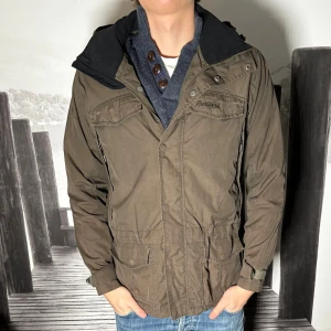 Grön parkajacka från Bergans - Säljer en grön parkajacka från Bergans med huva. Jag är 187cm och 75kg.