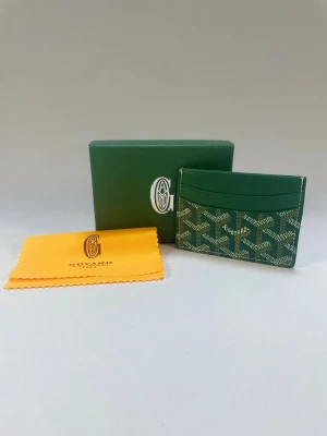 Grön korthållare  - Säljer en grön korthållare. Korthållaren har flera fack för kort. Helt ny oanvänd kan lösa bättre bilder vid önskan 