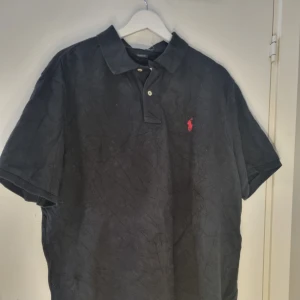 Ralph Lauren pike - Säljer en klassisk pikétröja från Ralph Lauren med korta ärmar. Perfekt för en stilren och avslappnad look.            