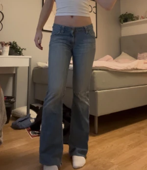 Blå bootcut jeans från Lee - Säljer ett par klassiska blå jeans från Lee med bootcut passform och låg midja. Midjemåttet rakt över är 38 cm och Innerbenslängden är 78 cm🤍
