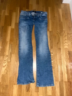 Blå bootcut jeans från LTB - Säljer ett par blå jeans från LTB med bootcut passform och klassisk femficksdesign. Jeansen har snygga slitningar och ljusare tvätt på låren och knäna. Perfekt för dig som gillar en avslappnad och trendig stil.
