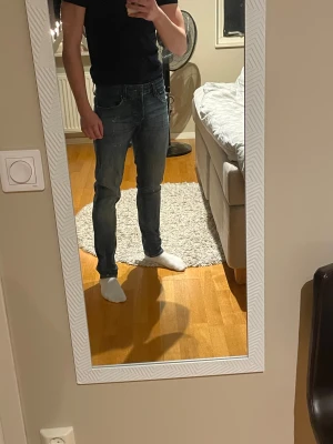 Blå jeans från Jack & Jones - Snygga blå jeans från Jack & Jones med slitna detaljer och klassisk femficksdesign. Byxorna är i storlek 32 längd och 31 waist