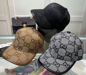 Gucci kepsar med GG-mönster - Tre snygga kepsar från Gucci med det klassiska GG-mönstret. Finns i svart, beige och grått, alla med böjd skärm och justerbar baksida. Materialet är canvas med detaljer i läder på beige och grå keps. Perfekt för att lyfta din streetwear-look.