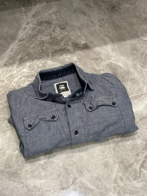 G-Star Raw Skjorta - G-Star Raw Skjorta | Blå | Varm | Skick: 9,5/10 | Storlek: L | Pris: 249 SEK | Priset är diskuterbart | Frakt: Postnord + Instabox + Bring | Skriv vid minsta fråga eller fundering 📩