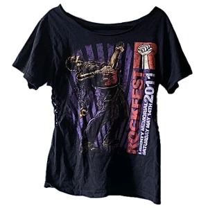 Cool emo tisha - Aaas snygg tisha från rockfest, är offshoulder och har sjukt coola detaljer på sidorna av midjan. Skit snygg men kmr inte t användning :((