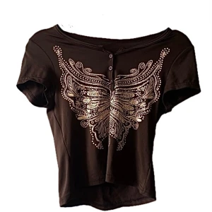 Brun topp - Brun topp me fjärils tryck, jättesöt men kmr tråkigt nog inte t användning</3 Materialet är väldigt stretchigt så kan även passa L!