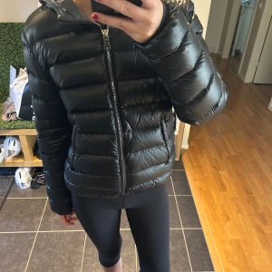 Svart dunjacka från Colmar med huva - Säljer en svart dunjacka från Colmar som är i nytt skick! Original pris är 5999kr. Prefekt jacka för kalla vinterdagar. Om du har några frågor är det bara att skriva privat 🫶🏼🫶🏼längd: 59 cm, bredden: 47 cm