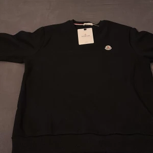 Svart Moncler tröja från Moncler  - Säljer en svart Moncler tröja den är i bra skick.passar storlek L och storlek M pris kan diskuteras genom snabb äffär