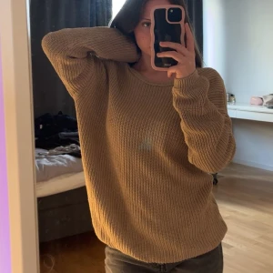 Stickad tröja NA-KD - Jag säljer min stickade tröja med öppen rygg som köptes på NA-KD i december 2021. Den är beige i färgen och i storlek XXS. Har använts en del men är i bra skick.