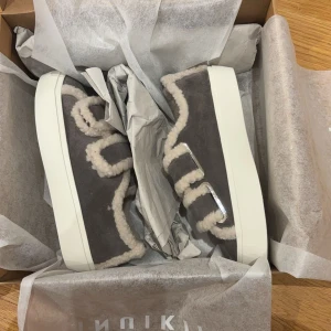 Inukki sneakers - INTRESSEKOLL på ett par grå sneakers från Inuikii med vit plattsula och mjuka fårullskanter. Skorna har en chunky look och stängs med kardborreband täckta av fårull. Perfekta för dig som vill ha något både mysigt och trendigt till höst och vinter. Köpta för 2700kr❣️❣️