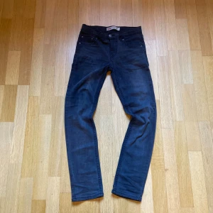 Levi's 511  - Snygga gråa Levi's 511 jeans med klassisk femficksdesign och smal passform. Jeansen har raka ben och är tillverkade i mjukt denimtyg som sitter skönt hela dagen. Perfekta för dig som gillar en stilren och modern look.