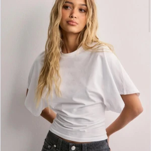 Vit T-shirt från Nelly  - Säljer en vit t-shirt från nelly. Super trendig. Tajt midja. Bra skick. Hör av er om ni har fråger eller vill ha fler bilder💞pris kan diskuteras!