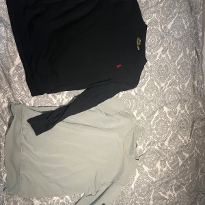 Svart långärmad tröja från stone Island och Ralph lauren  - Svart långärmad tröja från Polo Ralph Lauren med klassisk röd broderad logga på bröstet. Tröjan är i mjuk bomull och har en enkel, stilren design med rund hals. Perfekt för dig som gillar en clean och tidlös look. Den andra är en ljusgrön overshirt från stone Island.                                    299 för en tröja 450 för båda 👍 