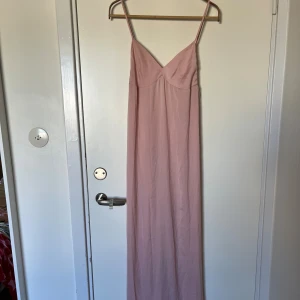 Ljusrosa nattlinne/slipklänning  - Supersöt ljusrosa nattlinne/slipklänning från Mint & Berry med tunna axelband och v-ringad urringning. Materialet känns lätt och svalt mot huden. Slits i sidan. Stl 34/XS. Använd 1 gång. 