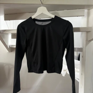 Långärmad träningstopp - Träningstopp, lite kortare i modellen. Nät på ryggen så luftar bra stl S