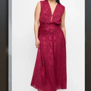 Vinröd långklänning med blommönster - Supersnygg vinröd långklänning från Bikbok med blommigt mönster och djup v-ringning. Klänningen är ärmlös och har en markerad midja med draperad detalj. Storlek stor XS. Helt ny endast provad! Nypris 899kr 