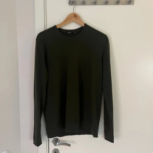 Olivgrön stickad tröja J.Lindeberg - Säljer en olivgrön stickad tröja från J.Lindeberg i storlek M. Tröjan har rund halsringning, diskret broderad logga på bröstet och är långärmad. Tröjan är i bra skick, tveka inte på att höra av dig vid frågor eller funderingar! Priset kan diskuteras.